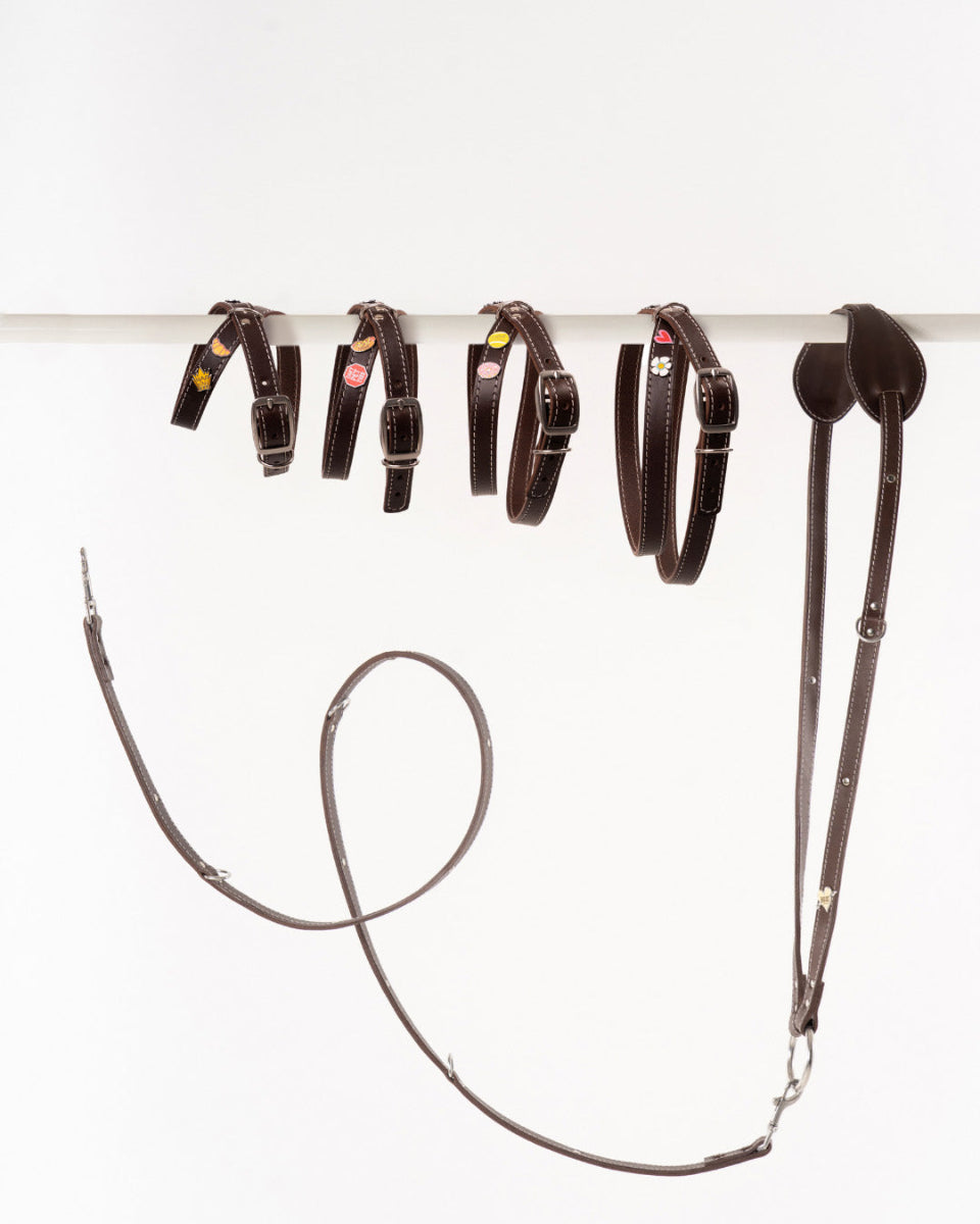 Handmade leather dog harnesses and leashes from Mou Mou Couture displayed on a white background