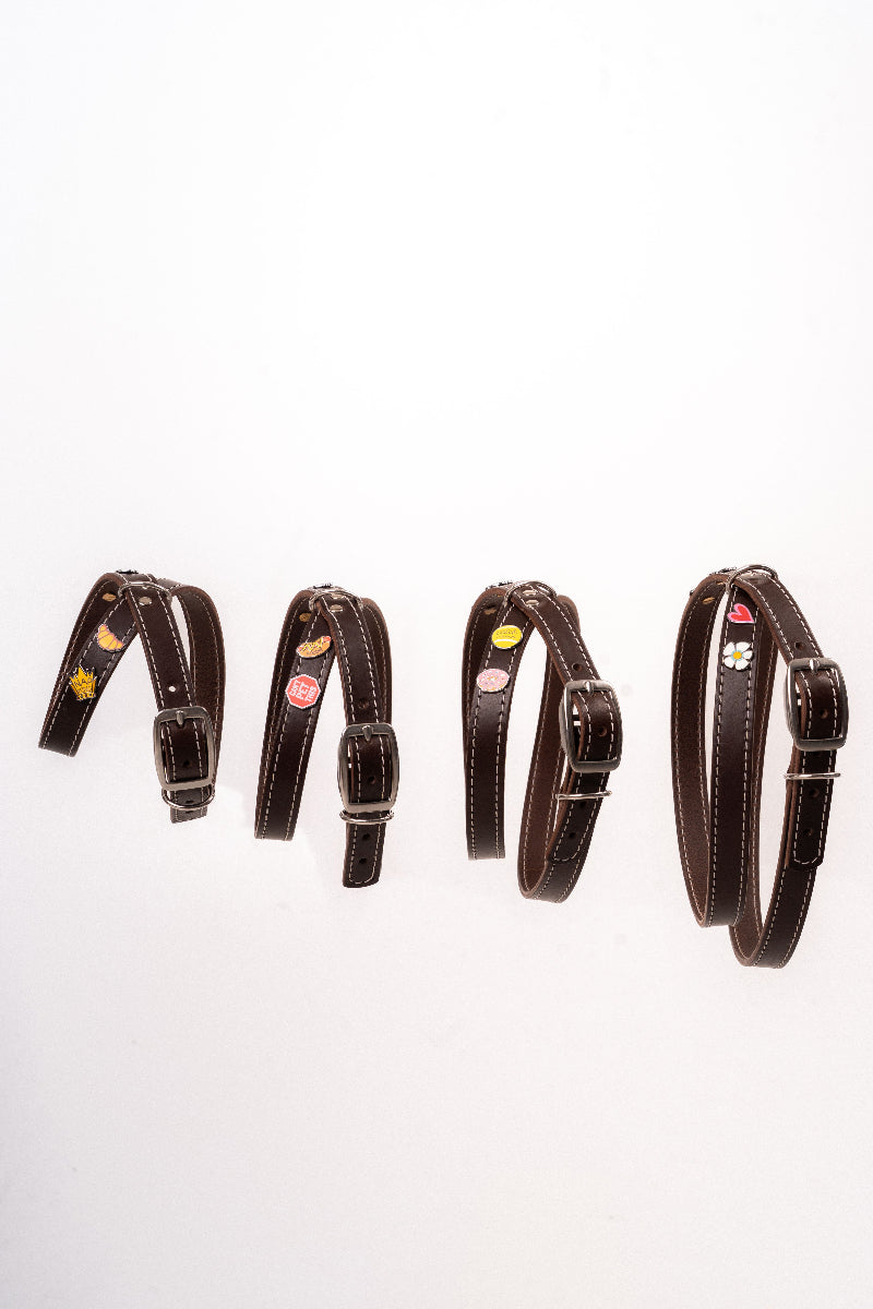 Handmade leather dog harness with colourful charms from Mou Mou Couture displayed on a white background