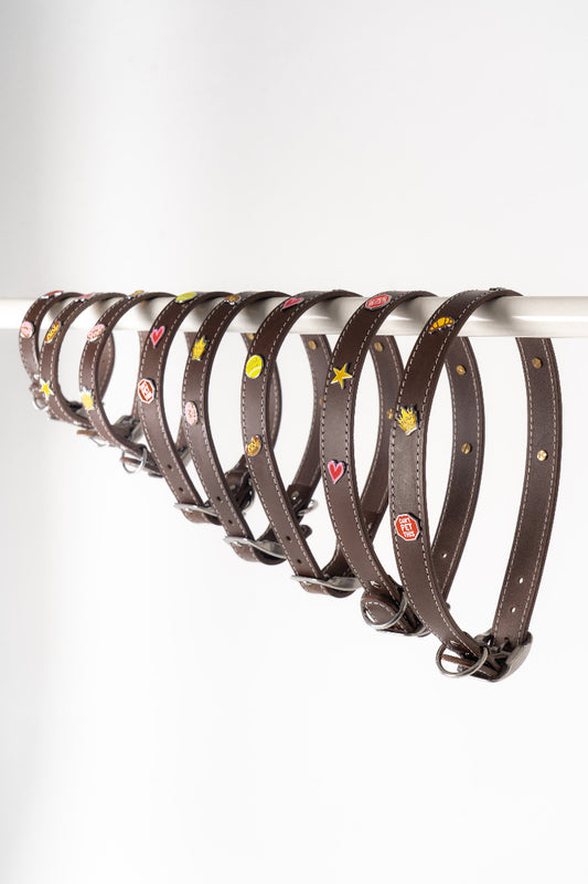 Handmade leather dog collars with colourful charms from Mou Mou Couture displayed on a white background